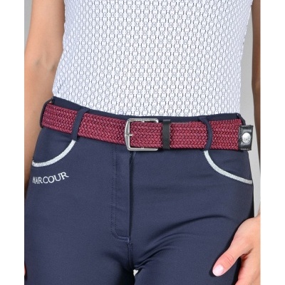 Cinto trançado vermelho com fivela prateada em calças azuis e blusa branca texturizada