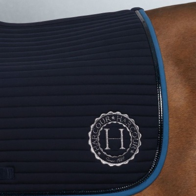 Tapete de sela azul escuro com borda azul claro e logo HARCOUR