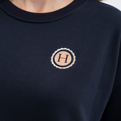 Camisola azul escura com bordado circular com a letra H no peito