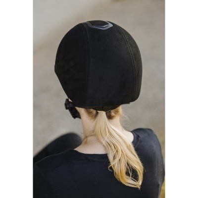 Capacete preto de ciclismo visto de trás numa pessoa com cabelo loiro e roupa preta