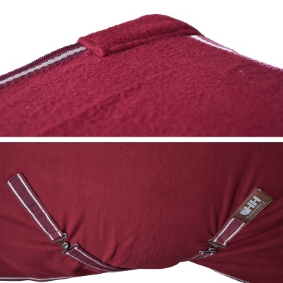 Almofada vermelha com tecido felpudo, tecido liso e alças às riscas com etiqueta HH