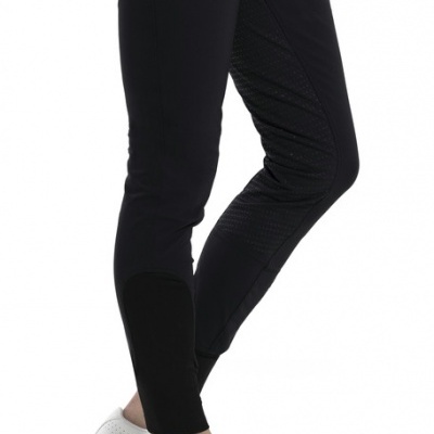 Calças pretas justas com detalhes perfurados e sapatilhas brancas.