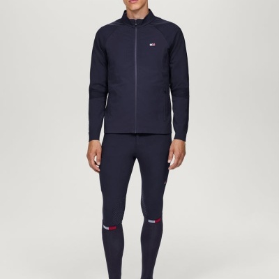 Homem com fato desportivo azul escuro com detalhes vermelhos e brancos