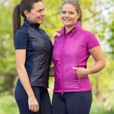 Duas mulheres com coletes desportivos azul escuro e rosa, outdoors em fundo natural
