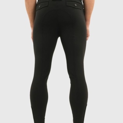 Calças justas pretas com bolsos traseiros e sapatos desportivos bege.