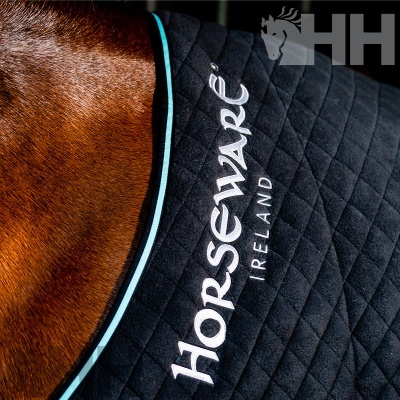 Tapete acolchoado preto para cavalo com texto HORSEWARE IRELAND e borda azul claro