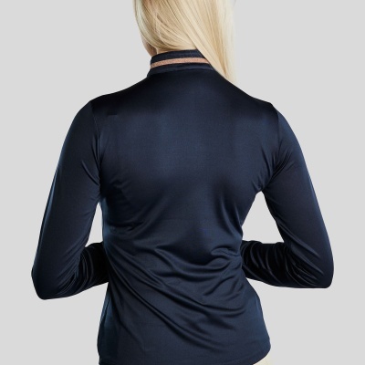 Mulher de costas com blusa azul escura de manga comprida e calças bege claras