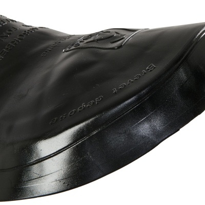 Sola de sapato preto de couro com relevo em padrão de rosa e texto em relevo.