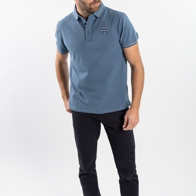 Homem vestido com polo azul e calças pretas