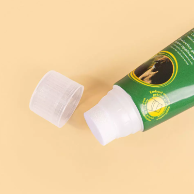 Tubo de gel verde com tampa branca transparente removida sobre fundo bege