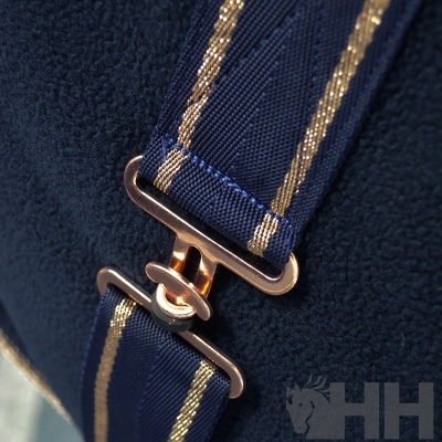 Alça azul com fecho metálico dourado sobre tecido azul escuro