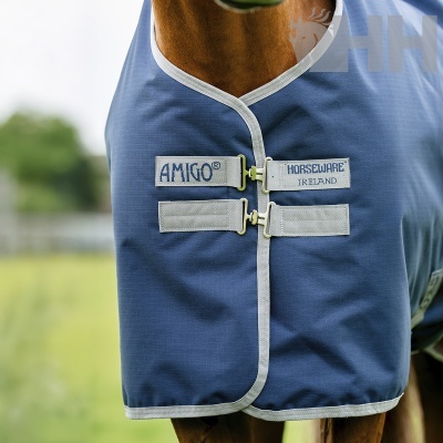 Cobertura azul para cavalo com fechos metálicos e etiquetas com texto AMIGO® e HORSEWARE IRELAND.