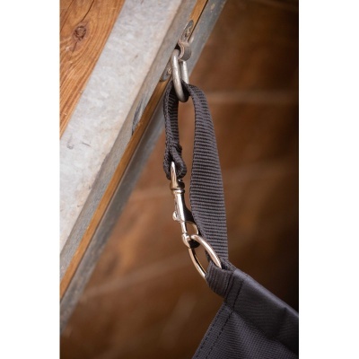 Pega de tecido preto preso a gancho de metal numa estrutura de madeira e metal