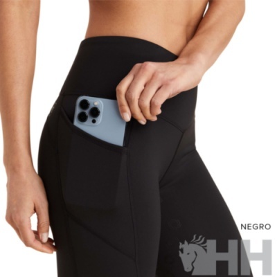 Calças leggings pretas com bolso lateral a segurar um telemóvel cinzento