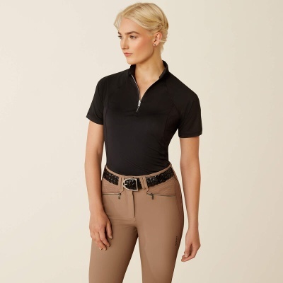 Mulher com camisola preta de manga curta e calças castanhas claras com cinto preto