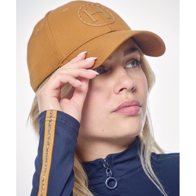 Boné castanho com logo em relevo usado por mulher com camisa azul e listra amarela