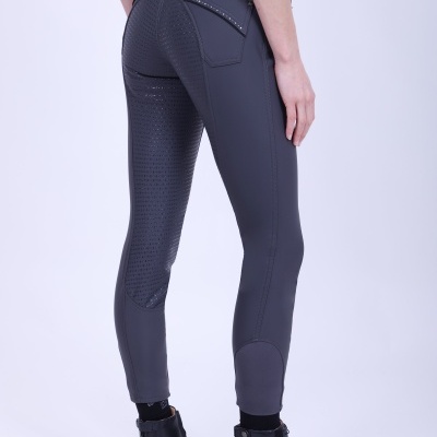 Calças justas de equitação cinzentas com textura antiderrapante e botas pretas.