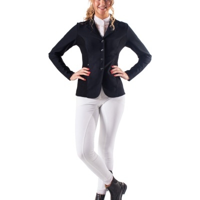 Mulher com blazer preto, camisa branca, calças brancas e botas pretas