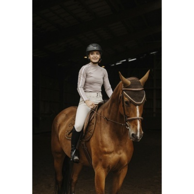 Mulher com equipamento de equitação montada num cavalo castanho com touca de equitação