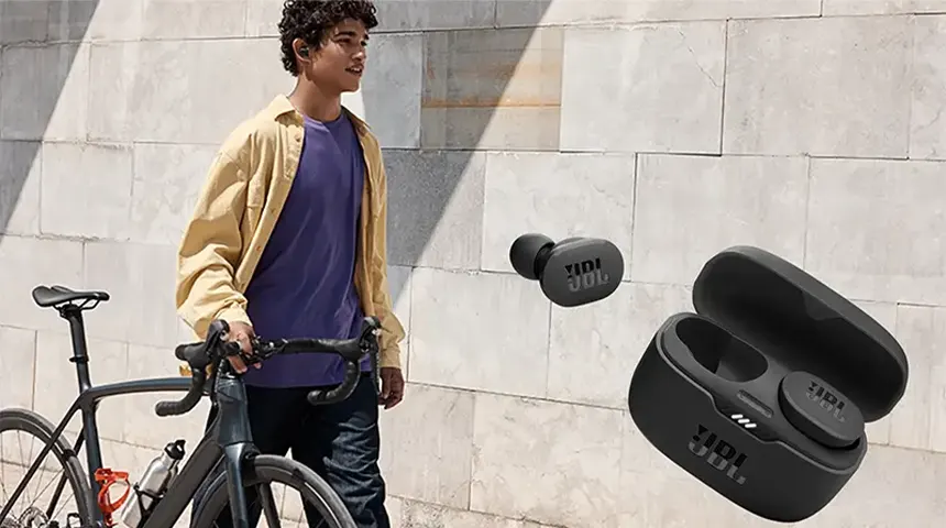Análise aos auriculares bluetooth JBL Tune 130NC TWS Jovem a pé junto a bicicleta preta com auriculares TWS JBL preto em estojo à frente