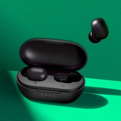 Auriculares sem fios pretos e estojo de carregamento aberto em fundo verde