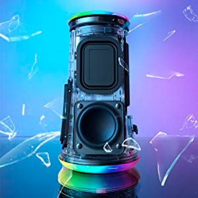 Coluna de som cylindrical com subwoofer visível e painel de controlo, estilhaços de vidro ao redor