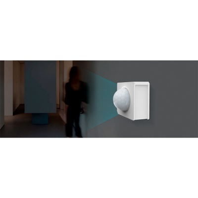 Sensor de movimento branco montado numa parede cinzenta com luz azul projetada