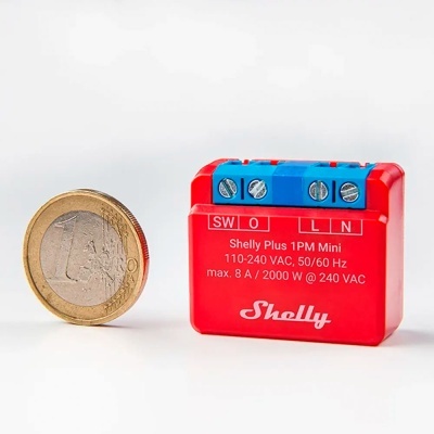 Módulo elétrico Shelly Plus 1PM Mini ao lado de uma moeda de 1 euro.
