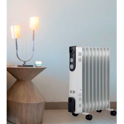 Radiador elétrico branco com 7 aletas ao lado de mesa de madeira com candeeiro dupla lâmpada