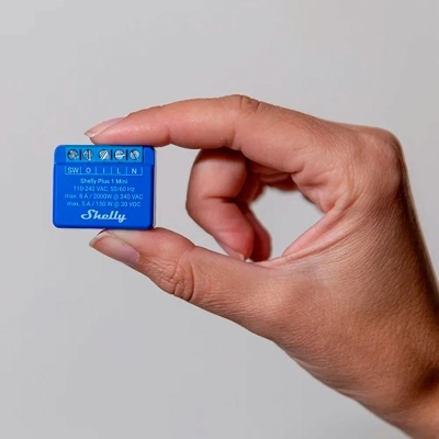Módulo eletrónico azul Shelly Plus 1 Mini segurado por mão