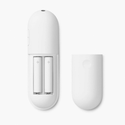 Comando remoto branco aberto com pilhas AA visíveis e tampa ao lado