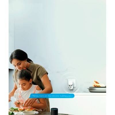 Duas mulheres na cozinha preparando comida com frigideira elétrica branca ligada na parede