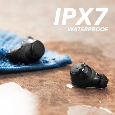 Auscultadores Bluetooth pretos molhados junto a pano azul e texto IPX7 WATERPROOF