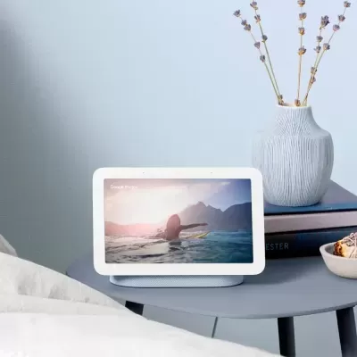 Tablet branco com suporte cinza numa mesa cinzenta junto a vaso branco e livros