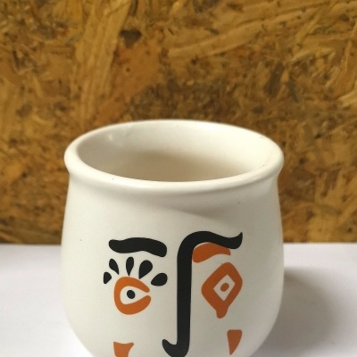 Caneca branca com rosto abstrato pintado em preto e laranja