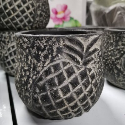 Vaso de cerâmica preto com padrão de abacaxi em relevo.