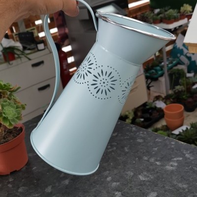 Regador metálico azul claro com padrão decorativo floral