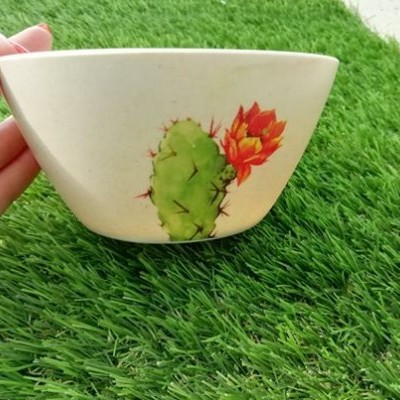 Taça branca com desenho de cacto em relva verde