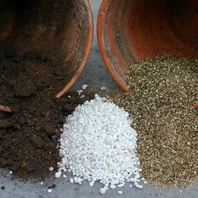 Quatro tipos de materiais granulados de substrato e terra em vasos de barro