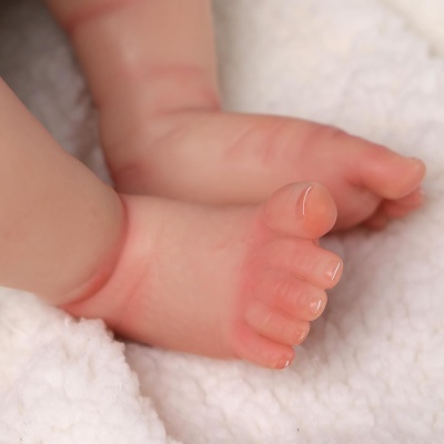 Pés de bebé sobre tecido branco felpudo