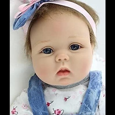 Boneca bebé realista com roupa azul e branca e fita de cabelo com laço