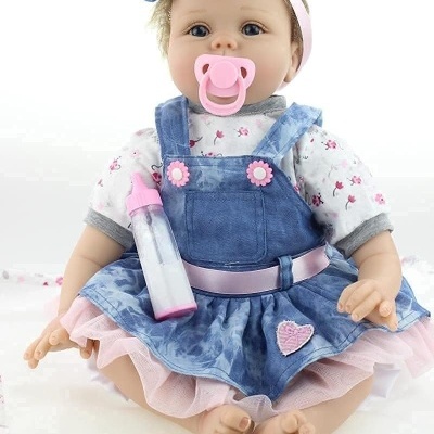 Boneca bebé com vestido azul de ganga e chupeta rosa