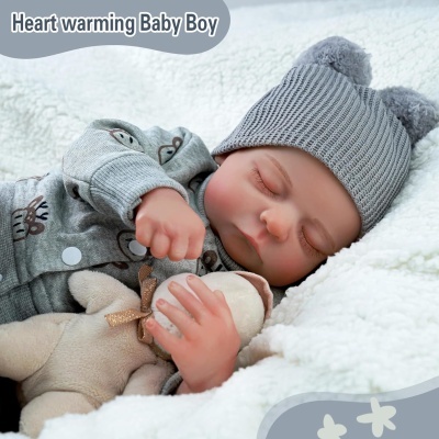 Boneco bebé menino vestido em pijama cinzento às tiras com estampas de veado, gorro cinzento com orelhas, segurando ursinho de peluche