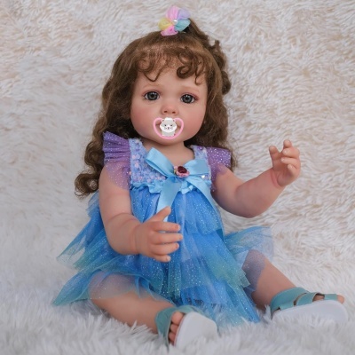 Boneca beb&eacute; com vestido azul e roxo sentada com chupeta rosa