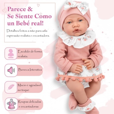 Boneca realista com roupa rosa e branca com padrão de flores sobre fundo branco e rosa claro