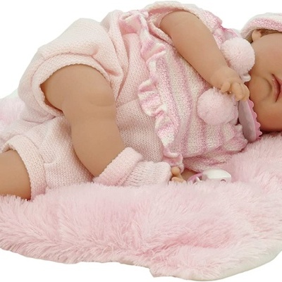 Boneca bebé vestida de cor-de-rosa a dormir sobre almofada rosa felpuda