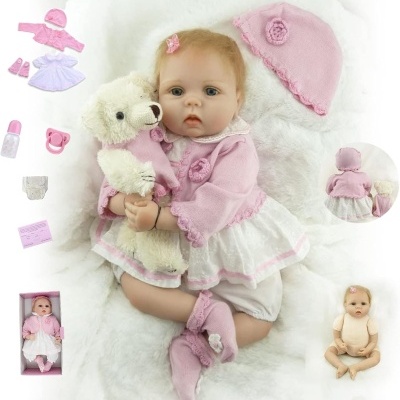 Boneca bebé realista com vestido branco e rosa a segurar ursinho de peluche