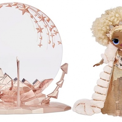 Boneca loira com vestido dourado e casaco branco ao lado de suporte rosa circular com estrelas