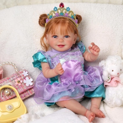 Boneca realista com vestido roxo e azul, coroa colorida, sentada com bolsa rosa, bolsa amarela e ursinho branco.
