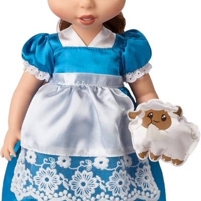 Boneca vestida de azul com avental branco e ovelha de pelúcia